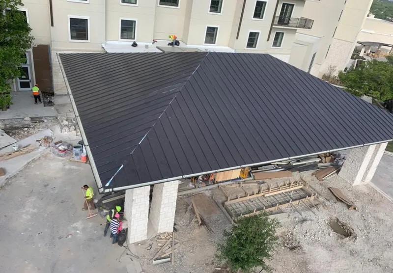 Metal roofing installation team working on a commercial building in Oakland Park